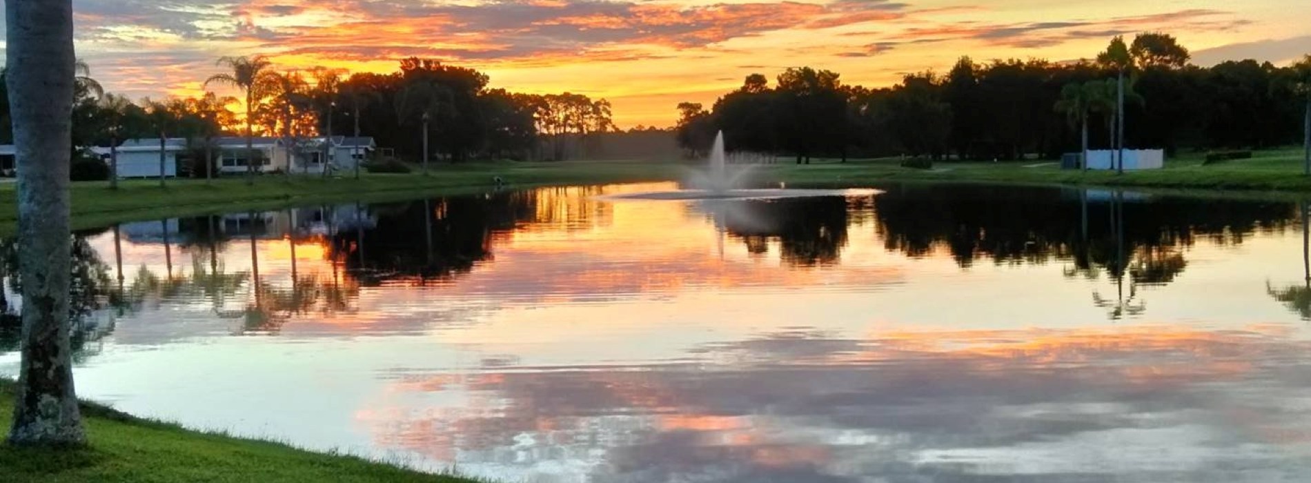 View of golf course green and lake